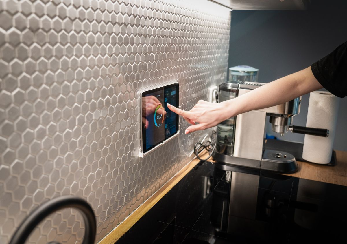 Wall-mounted smart home control panel in a modern kitchen